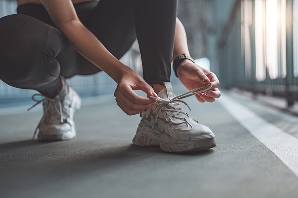 Person tying an athletic shoe.