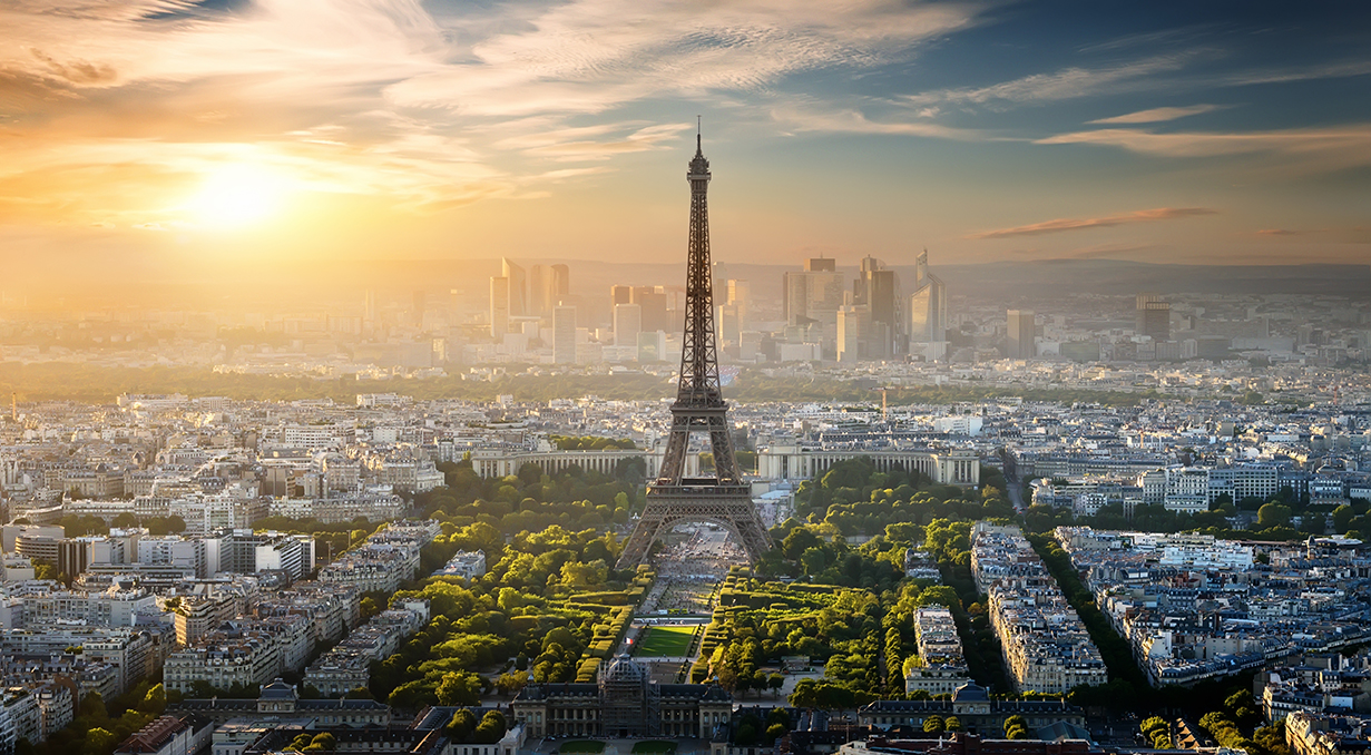 Aerial view of Paris and the Eiffel Tower on a sunny day with sparse clouds in the sky