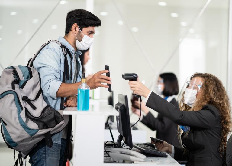 Man checks in to flight at airport during pandemic.
