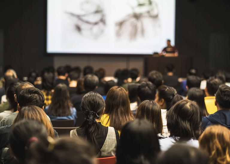 Audience looking at a speaker during conference