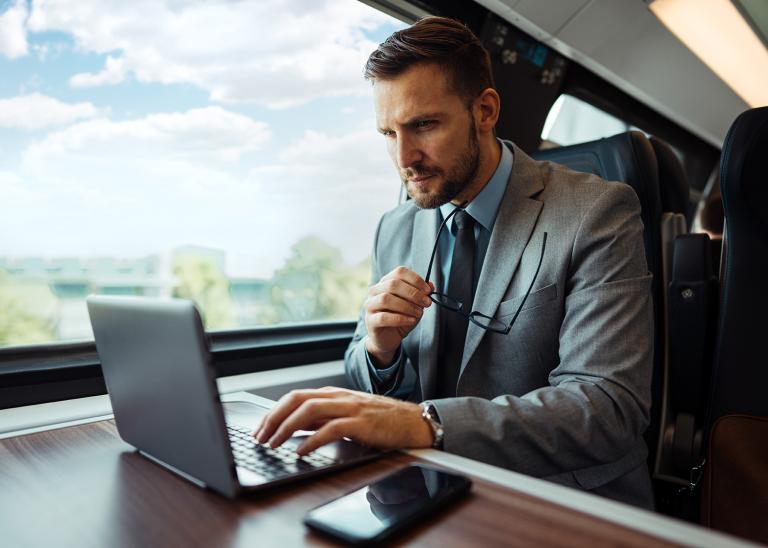 Executive working on a laptop while traveling on a train