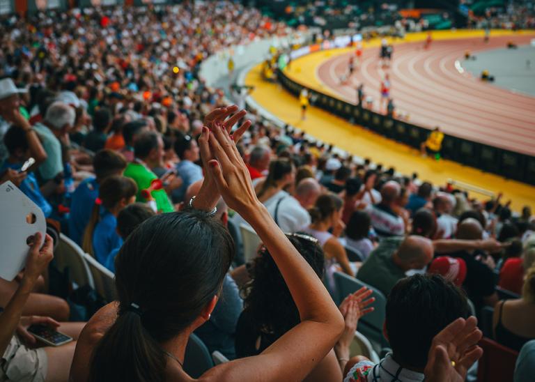 Fans support track and field event in a stadium.