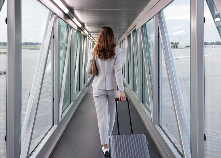 Businesswoman boarding the plane with carry-on