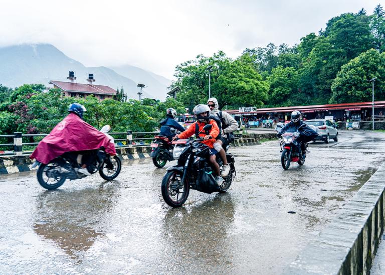 Motorbikes driving across flooded roads in Nepal due to monsoon season.