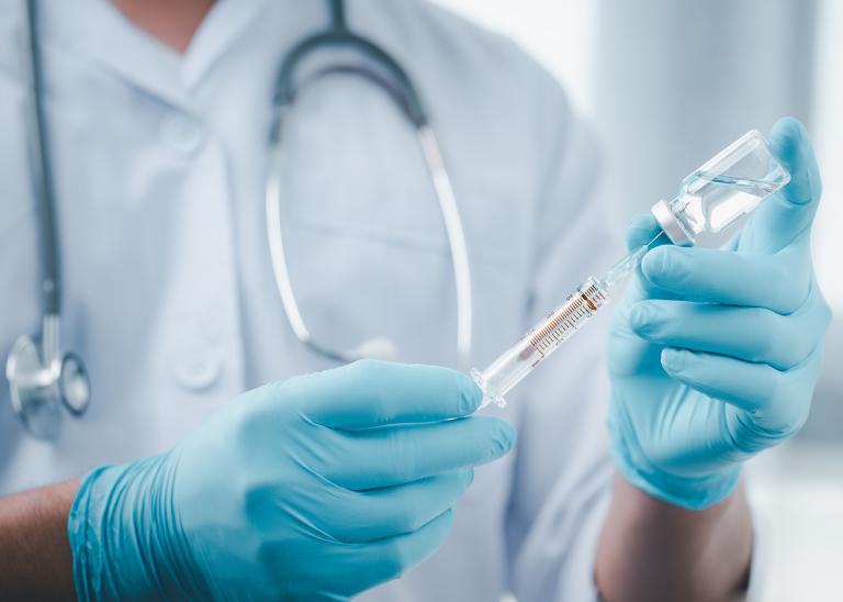 doctor or scientist holding a syringe with a liquid vaccine