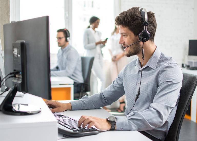 worker at desk taking a phone call