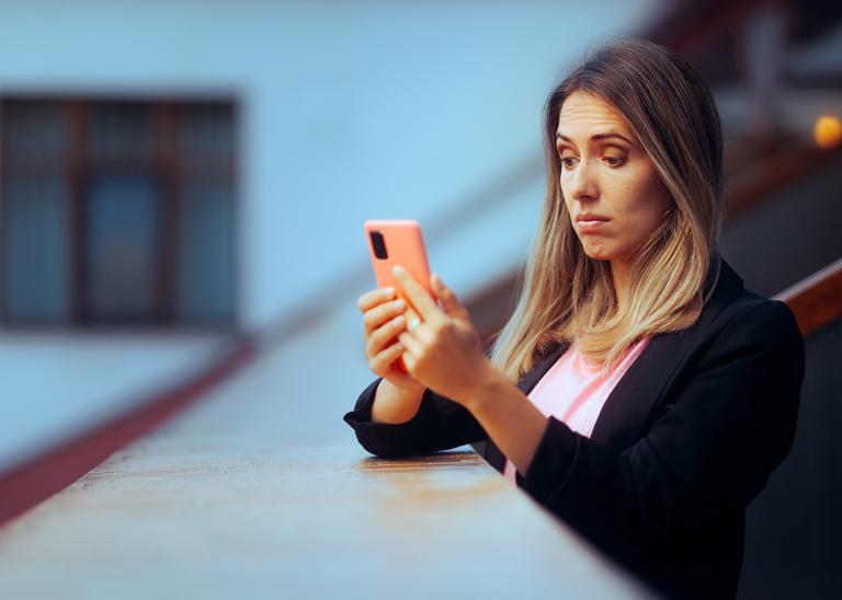 woman reading phone with a puzzled expression