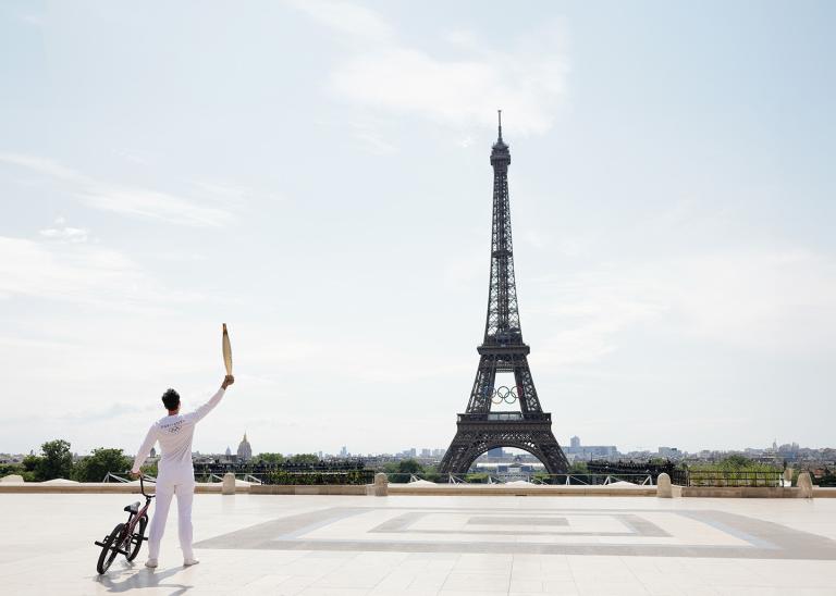 athlete standing with bike in front of Eiffel tower in Paris