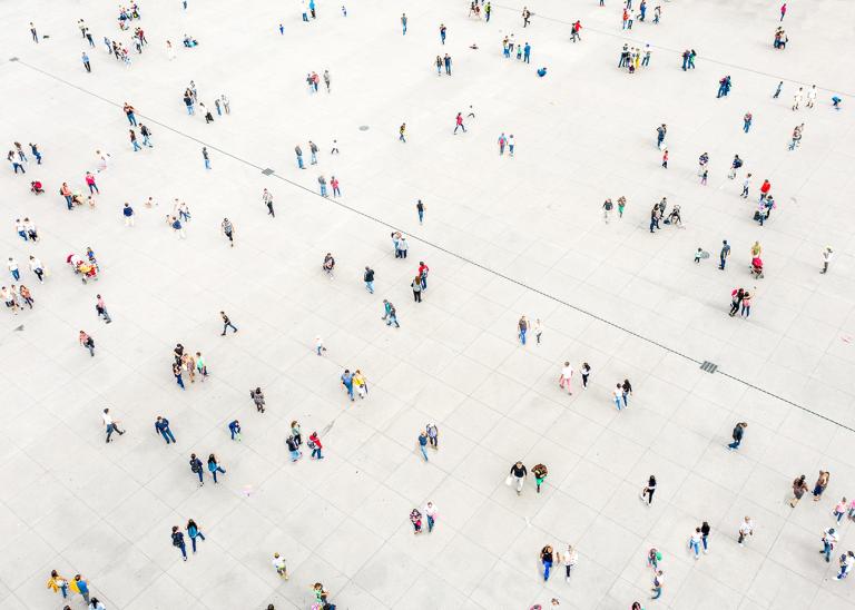 overhead view of a plaza with several people walking in different directions